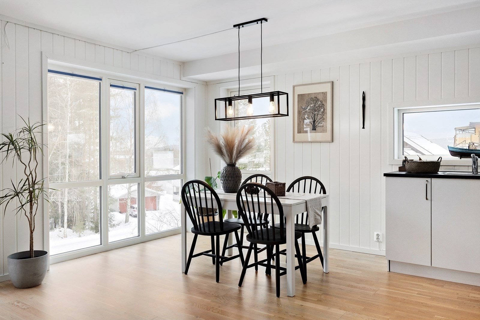 Hyggelig spisehjørne ved store vindusflater med fint utsyn. Det er persienner i vinduene. Galleribilde