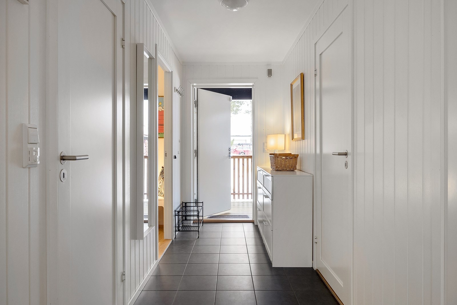 Lys og innbydende entré med flislagt gulv. Varme i gulv for ekstra komfort. Det er plass til kommode og oppheng for yttertøy og sko. Galleribilde