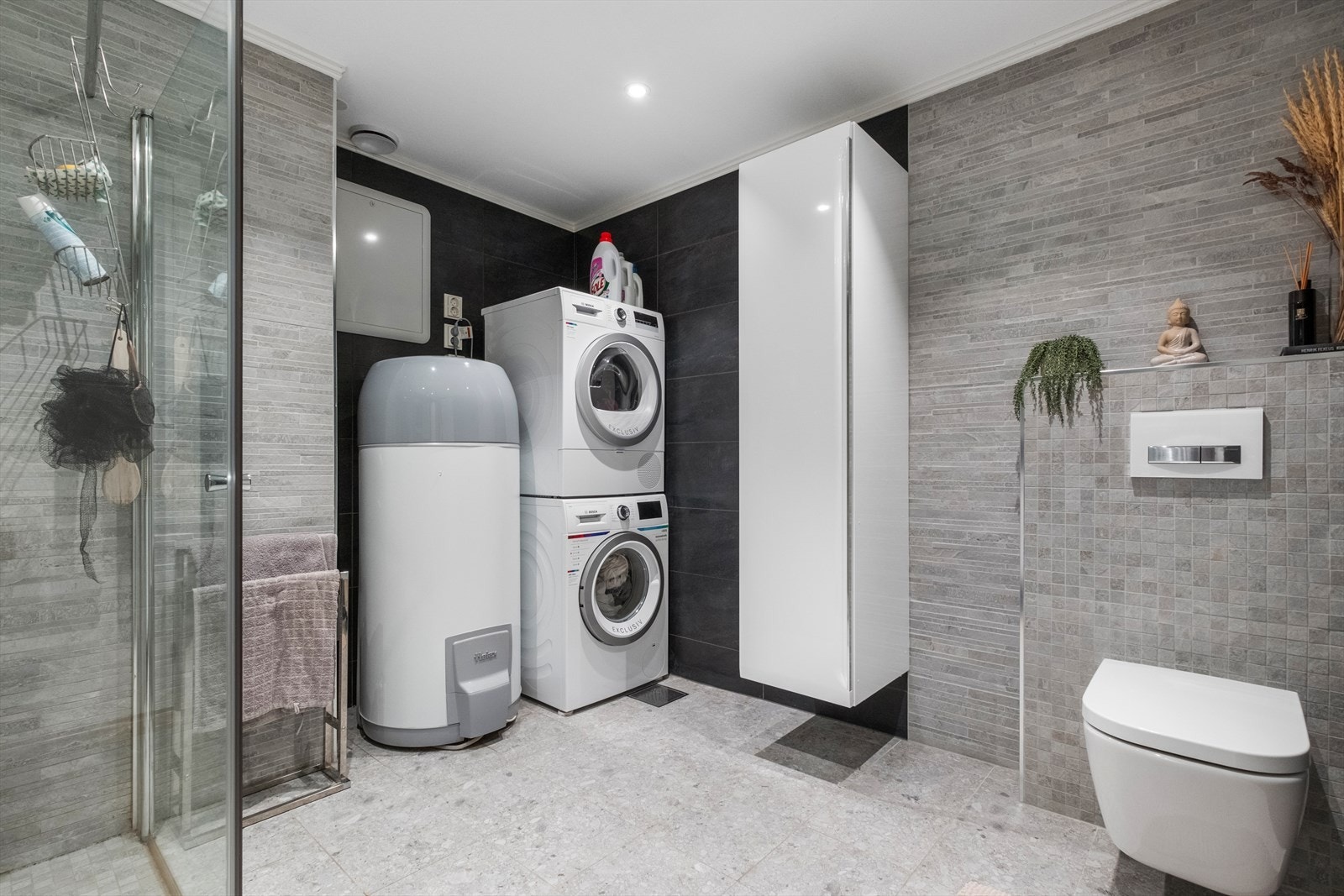 Vaskemaskin og tørketrommel er praktisk plassert ved siden av varmtvannsberederen. Galleribilde