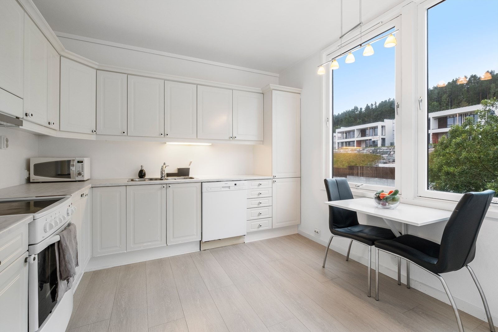 Kjøkkenet har profilerte fronter og benkeplate av laminat, samt kjøkkenventilator med avtrekk ut. Galleribilde