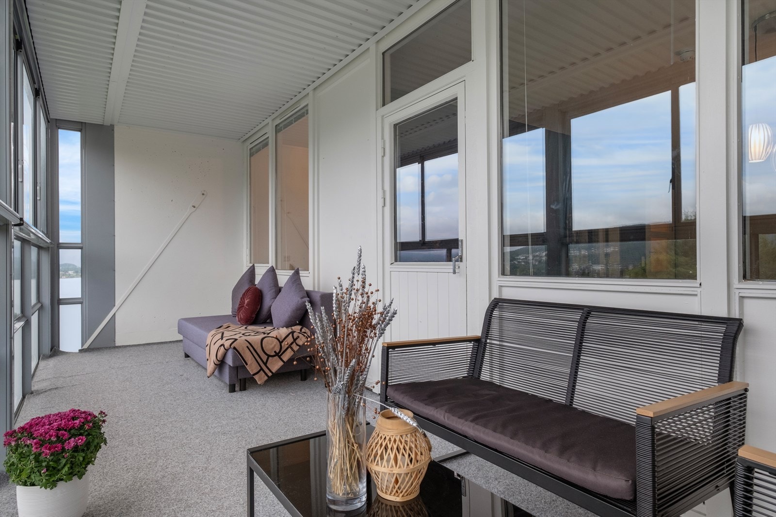 Balkongen er utstyrt med skyvbare vinduer og har dekke av betong med teppe for komfort. Galleribilde