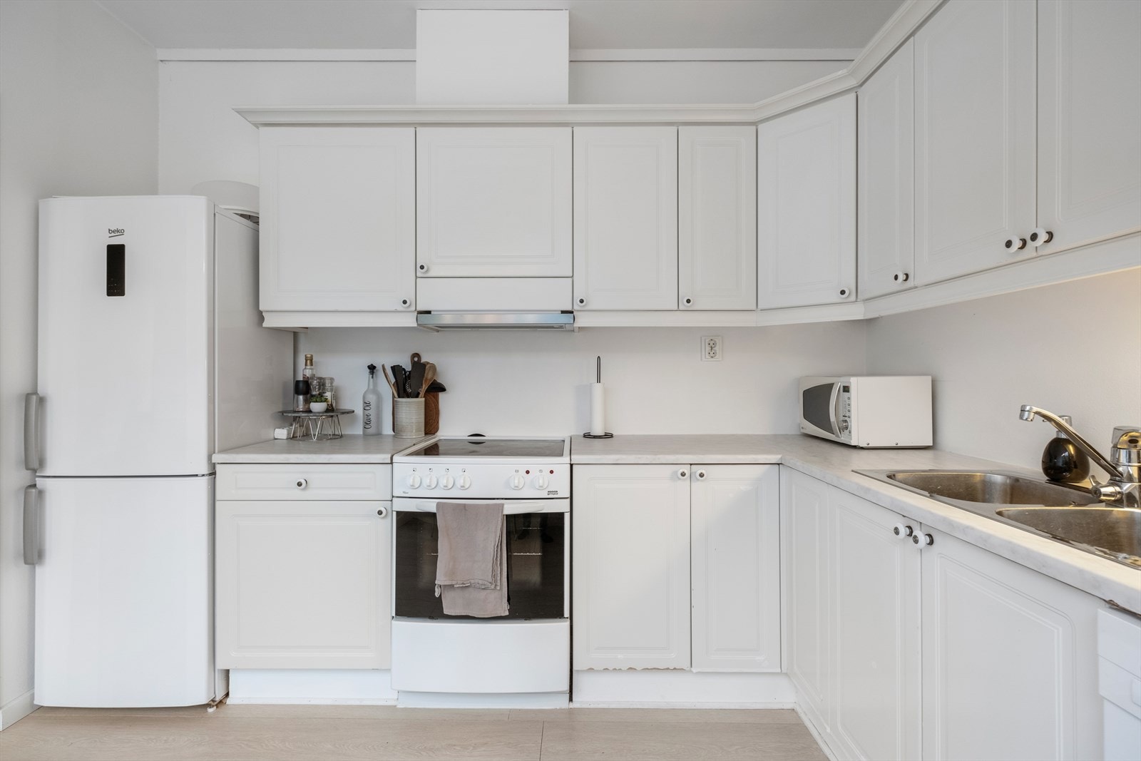 Innredningen viser profilerte fronter med laminat benkeplate, samt en praktisk kjøkkenventilator. Galleribilde