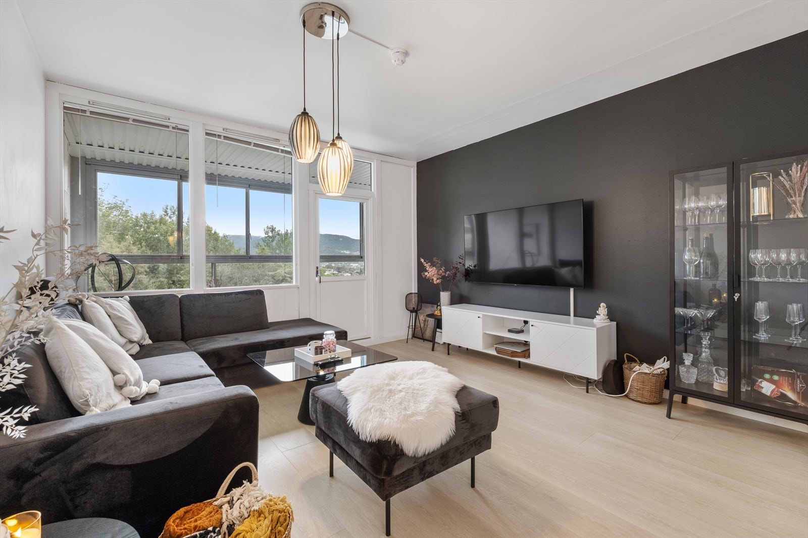 Store vindusflater gir utsyn mot grøntområder fra stuen. Galleribilde