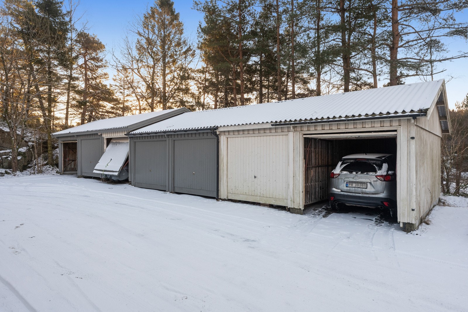 Boligen har en tilhørende garasje i rekke samt del av fellestomt med gjesteparkering. Garasjen ligger rett nedenfor boligen. Galleribilde