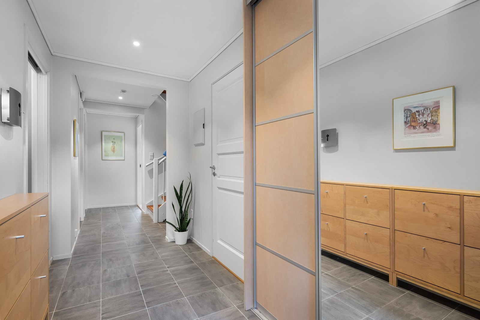 I gangen er det innebygget skyvedørsgarderobe, i tillegg til god plass til øvrig oppbevaring og til å henge fra seg yttertøy. Galleribilde