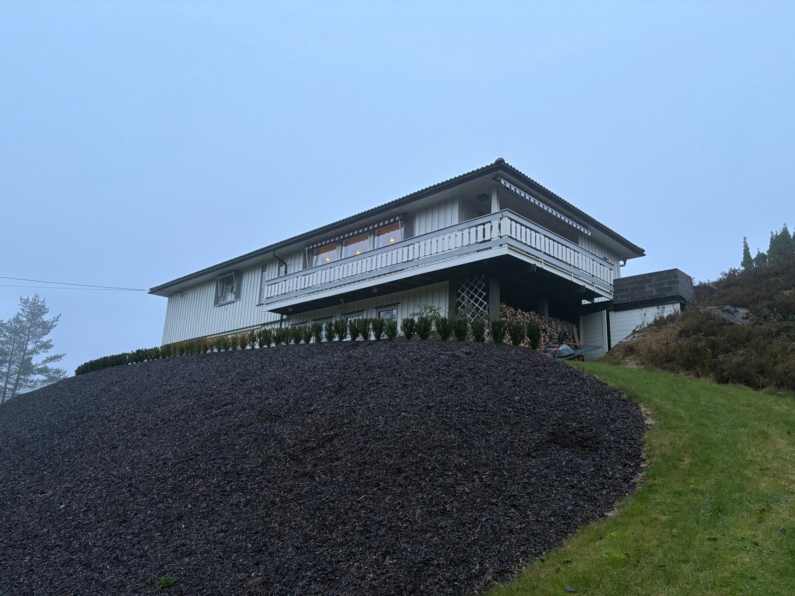 Pent opparbeidet hage med hekkplanter og bark i skråning. Galleribilde