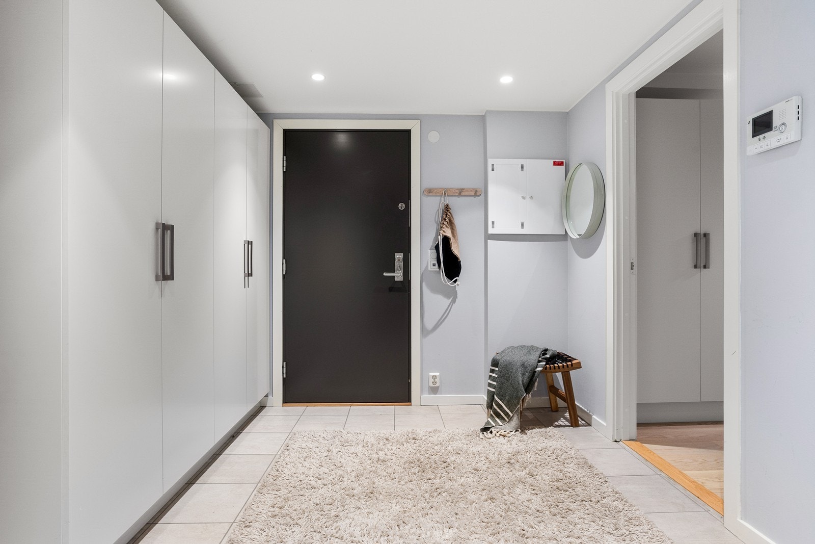 Flislagt gang med god plass til oppbevaring av yttertøy i gang. Galleribilde