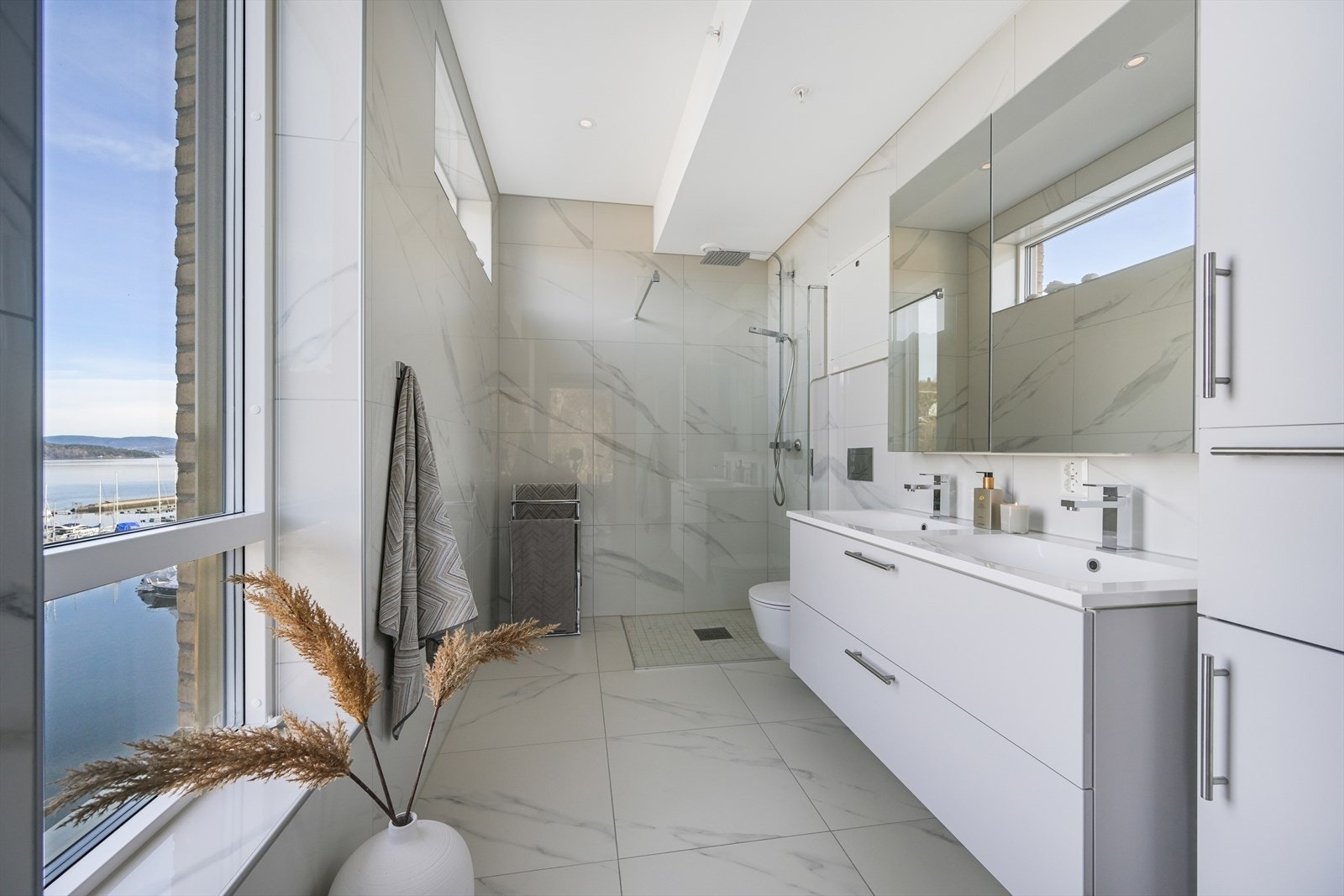 Tilhørende hovedsoverommet finner vi et privat baderom som er gjennomført med flotte 60 x 60 cm fliser i moderne fargetoner på vegger og gulv i lys marmorutførelse. Galleribilde