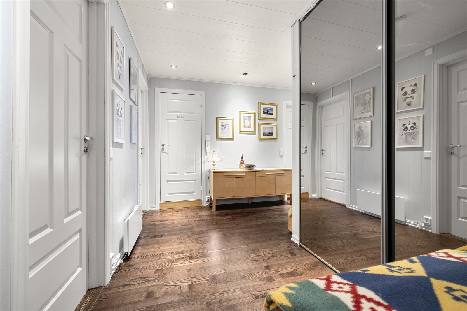 Romslig entré med adkomst til alle rom og gjennomgående panel på veggene. Galleribilde