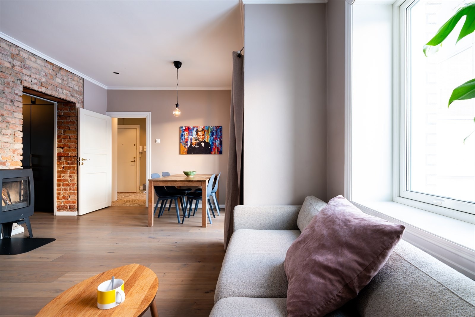 Stue og spisestue ligger i et stort og åpent rom med tilkomst fra entréen og videre adkomst til både kjøkken og ett av boligens soverom samt balkongen. Galleribilde