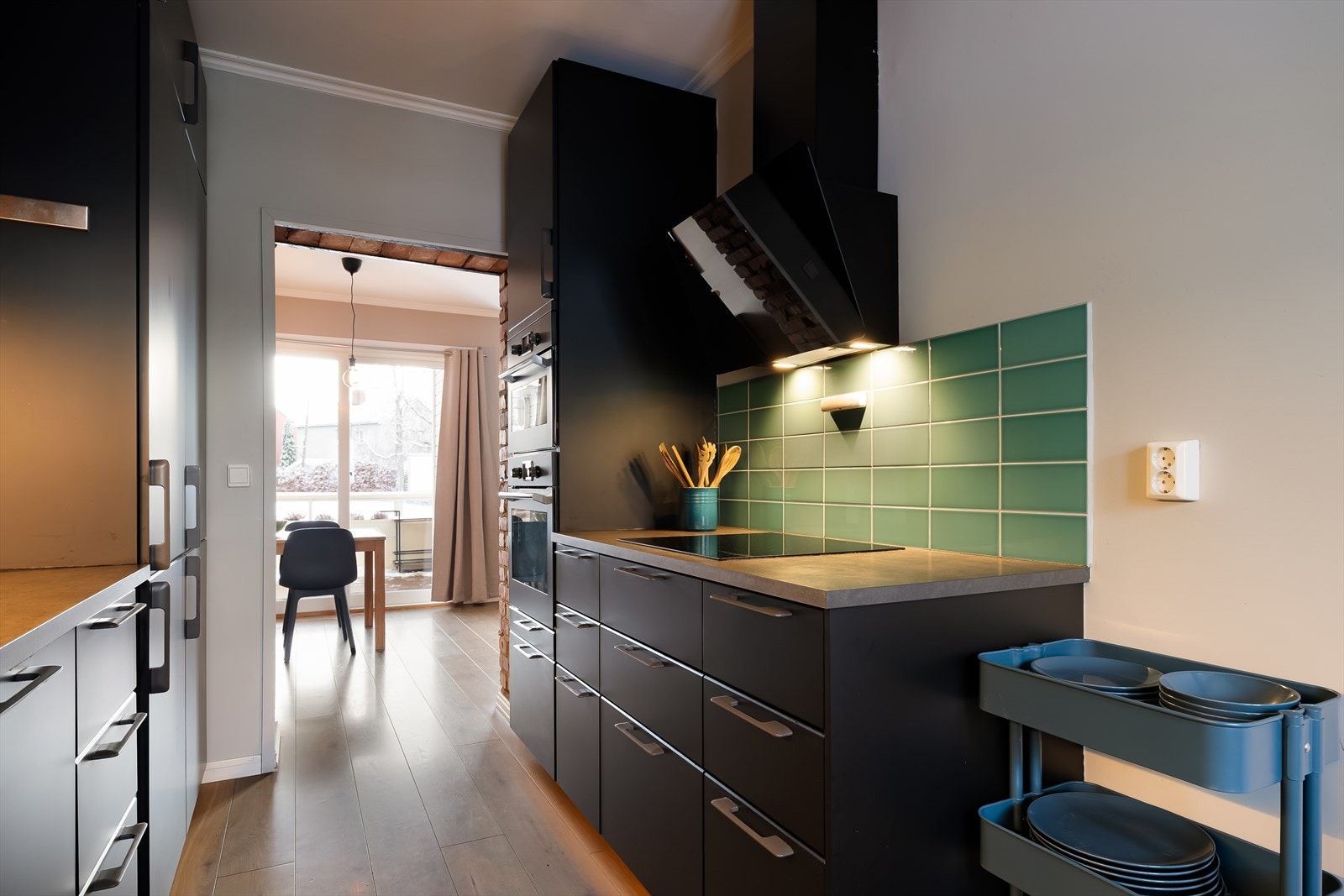 Det er fliser på veggen over benkeplatene og LED-lys under overskapene. Galleribilde