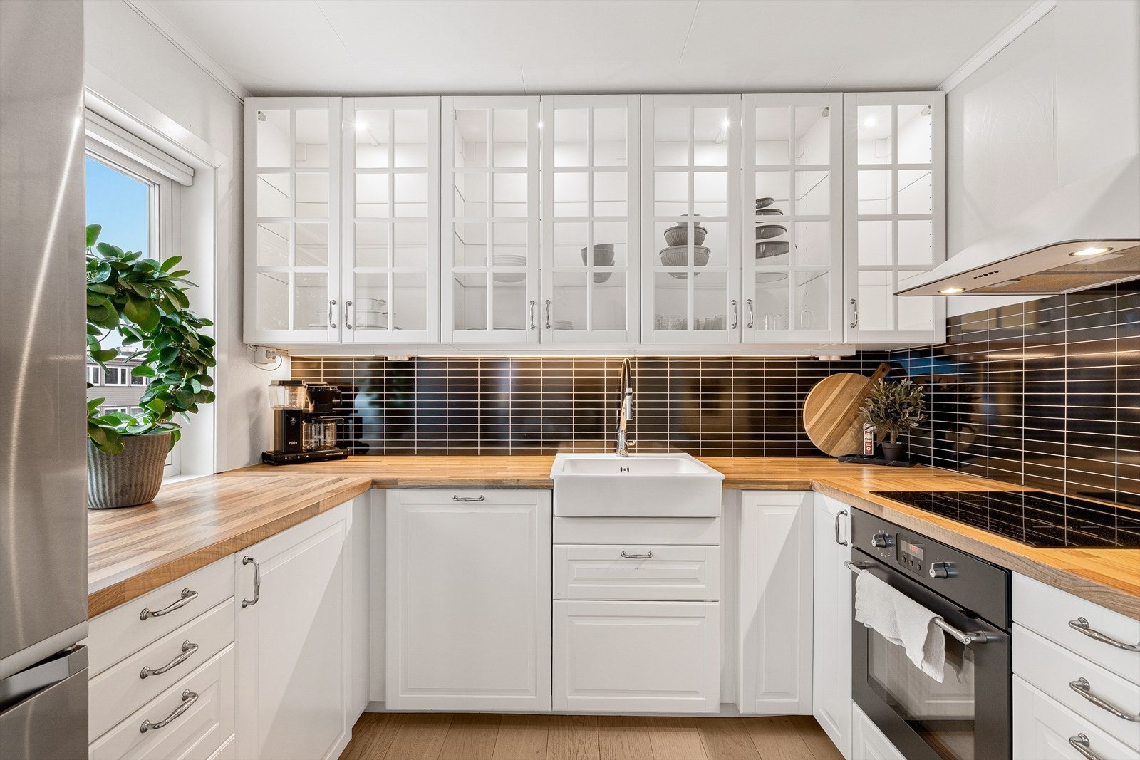 Lys og pen kjøkkeninnredning med profilerte fronter. Integrert ovn og platetopp. Samt oppvaskmaskin., Galleribilde