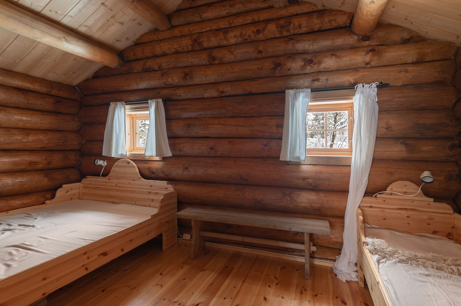 Tømmervegger og furugulv gir rommet et solid og naturlig preg. Malte trevinduer med sprosser slipper inn dagslys. Galleribilde