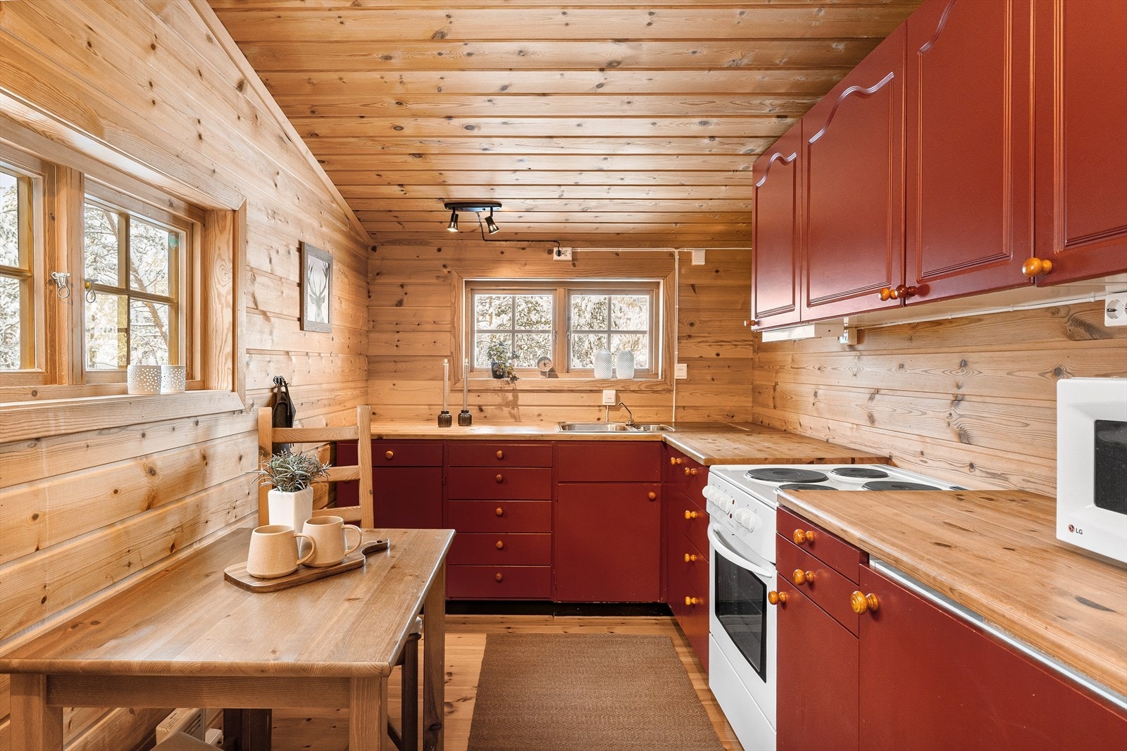 Benkeplater av tre, og heltre innredning. Det er vask, komfyr med platetopp, og mikrobølgeovn på kjøkkenet. Galleribilde