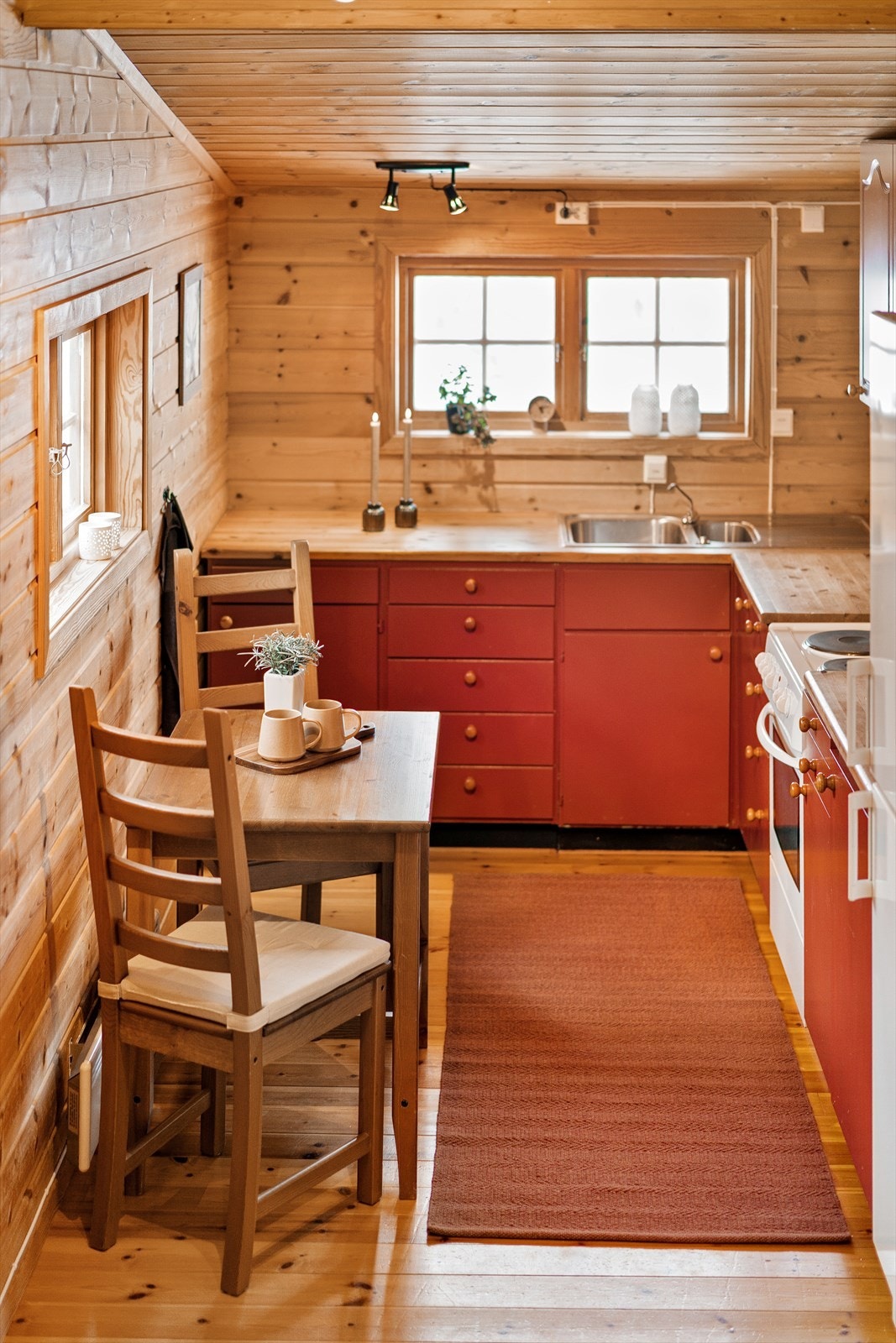 Kjøkkenet er et klassisk hyttekjøkken i vinrød farge. Galleribilde