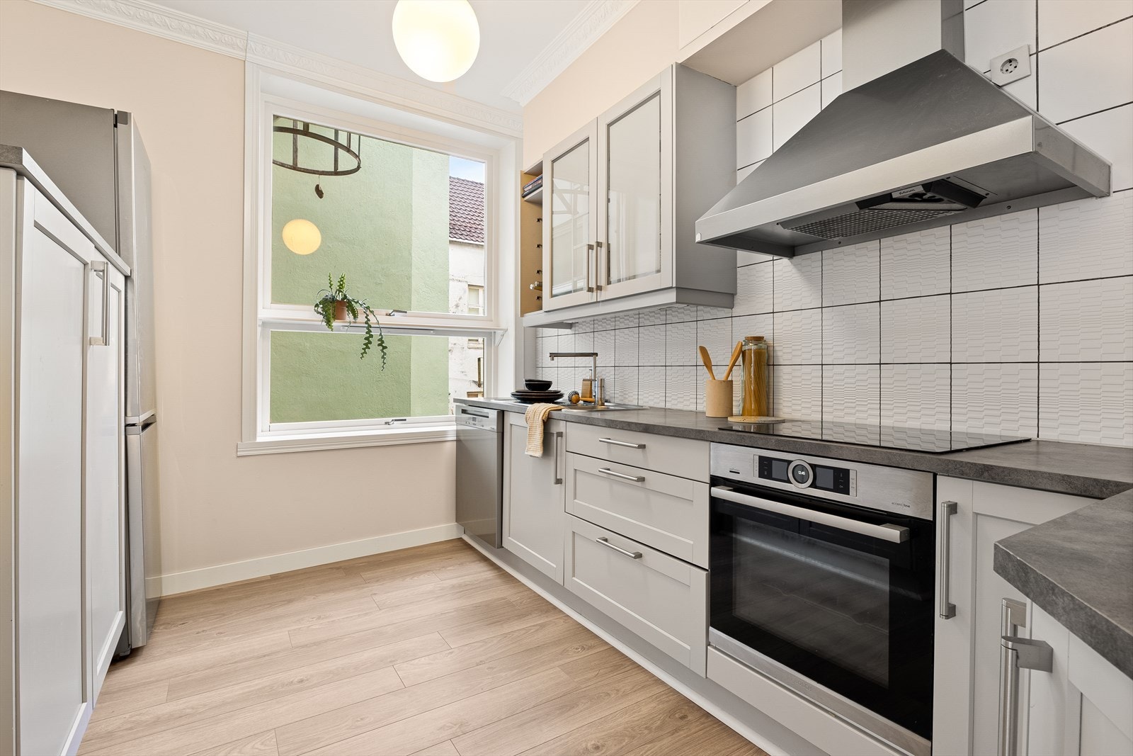 Lyst kjøkken med god benkeplass og vindu som gir naturlig lys og utsyn. Galleribilde