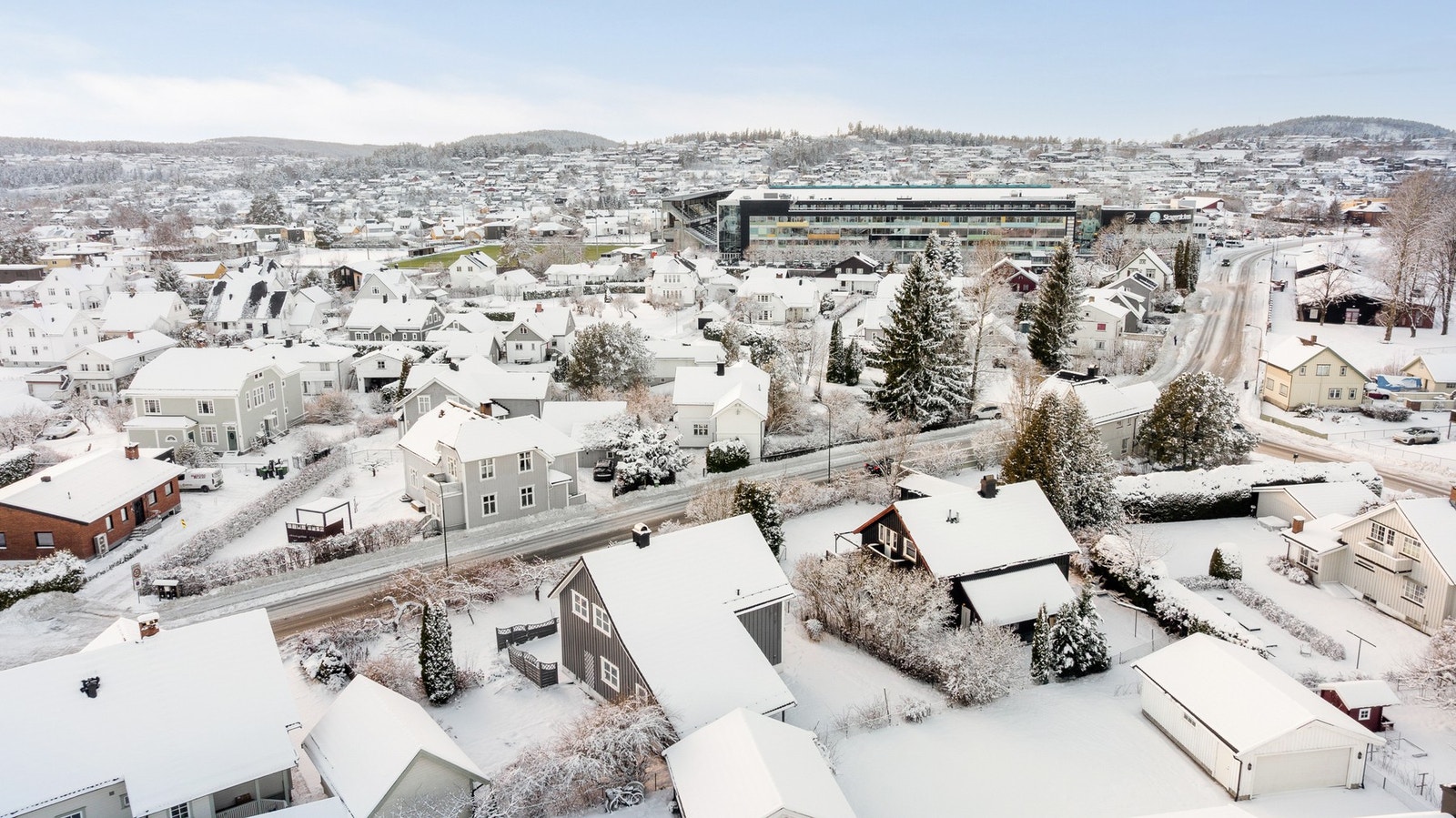 Boligen ligger i et veletablert nabolag på Falkum i Skien, i bakgrunnen ser man Skagerak Arena med butikker, treningssenter, frisør og skole Galleribilde