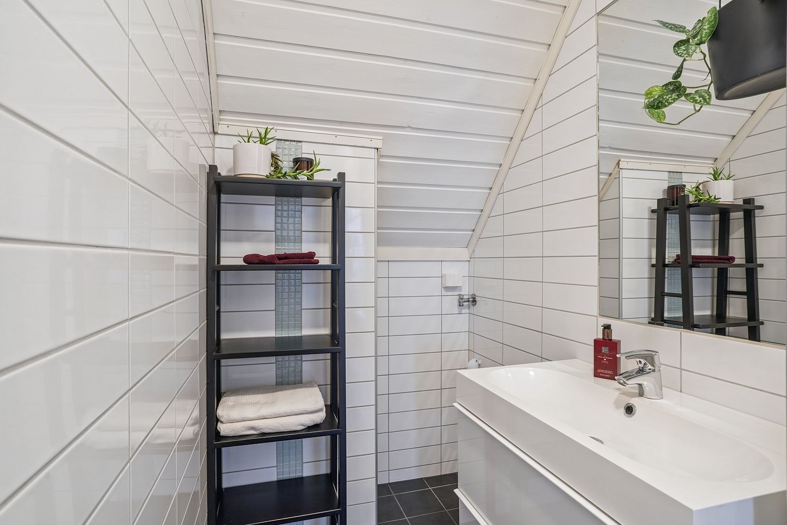 Badet har dusjnisje og opplegg for vaskemaskin Galleribilde