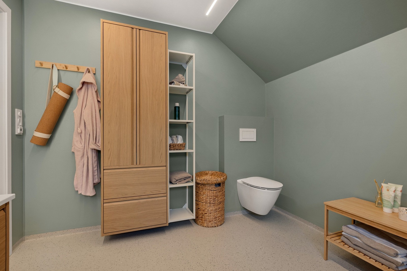 Bad med vegghengt wc med innebygget sisterne - og praktisk oppbevaring i langskap. Galleribilde