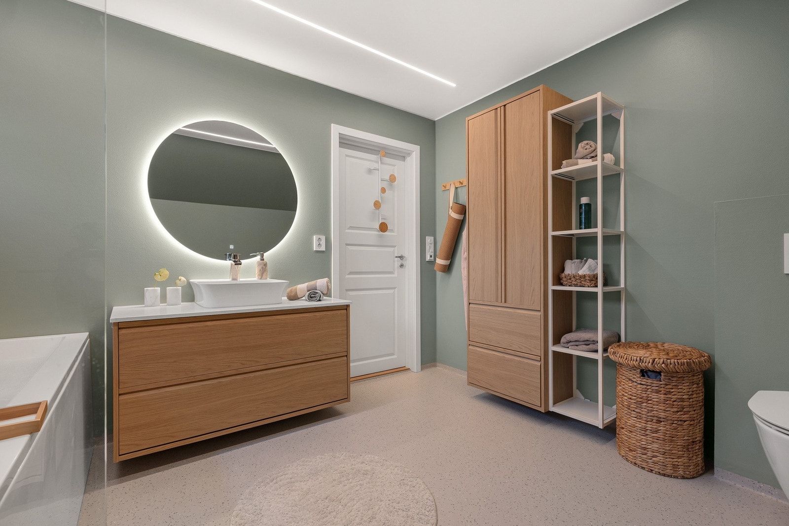 Romslig bad med servantinnredning, god oppbevaringsplass og stilrent uttrykk. Galleribilde