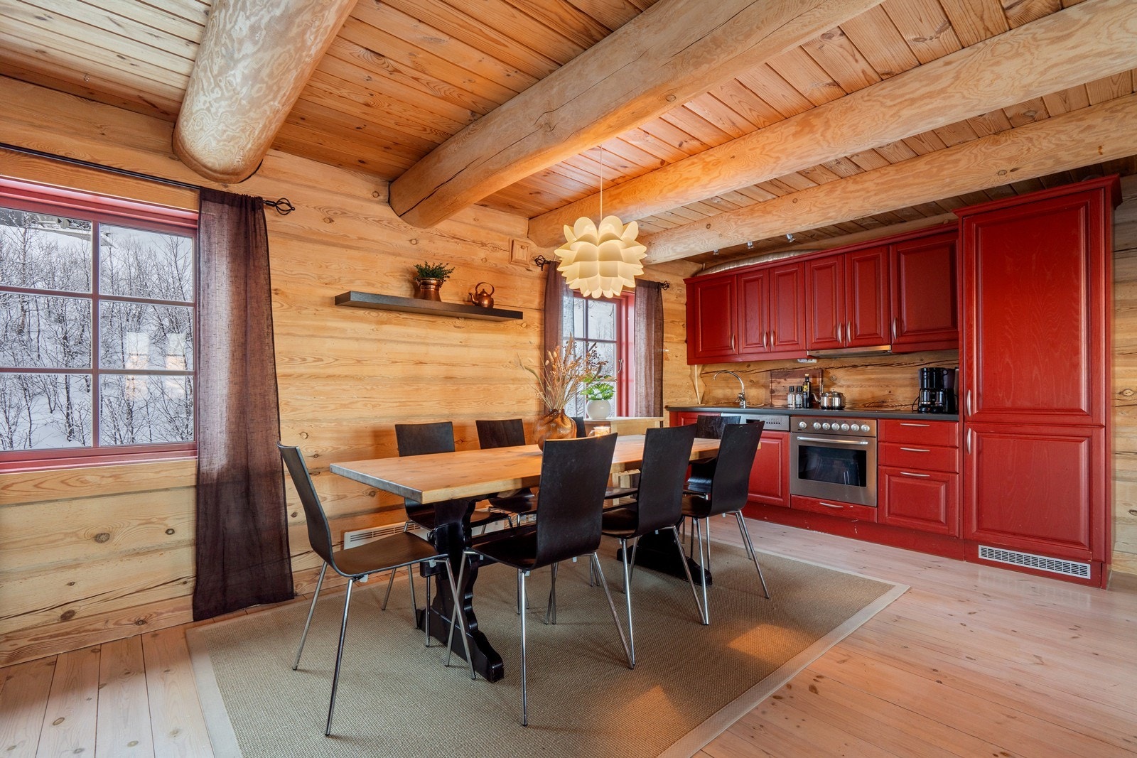 Synlige takåser og laftevegger skaper en autentisk og lun hytteatmosfære, mens flott furu heltregulv gir rommet et naturlig og innbydende preg. Galleribilde