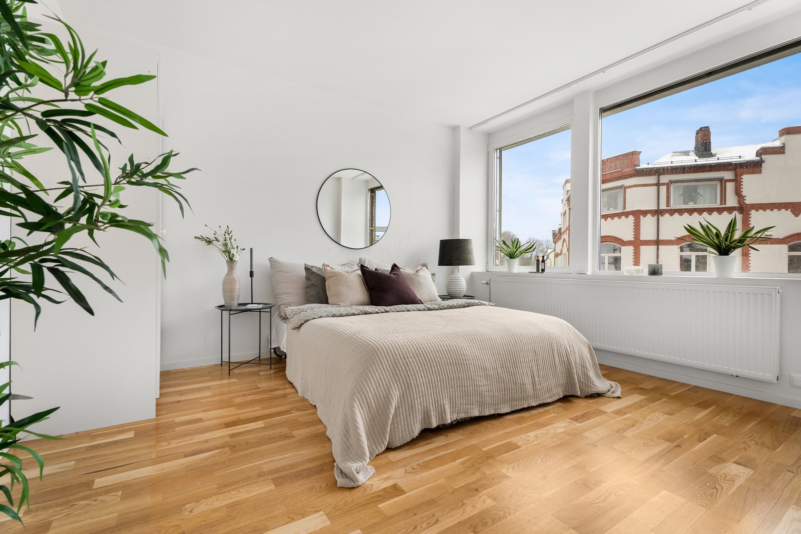 Leiligheten har et luftig og pent soverom med hvitmalte vegger, gyllent, trestavs parkettgulv og listfrie overganger til hvit himling. Galleribilde