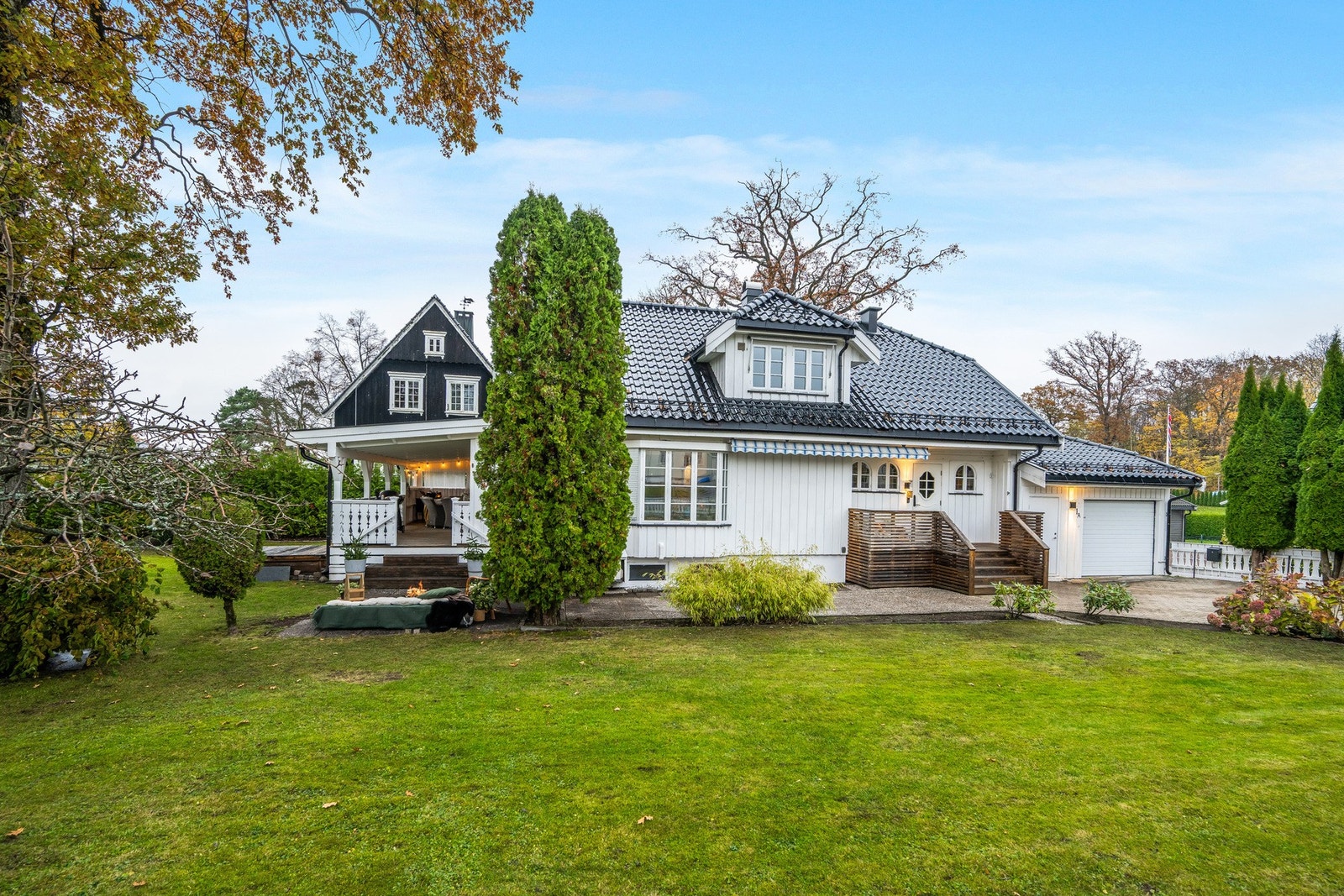 På den flotte tomten er det både eiketrær (fredet), prydbusker, plen og beplantning Galleribilde