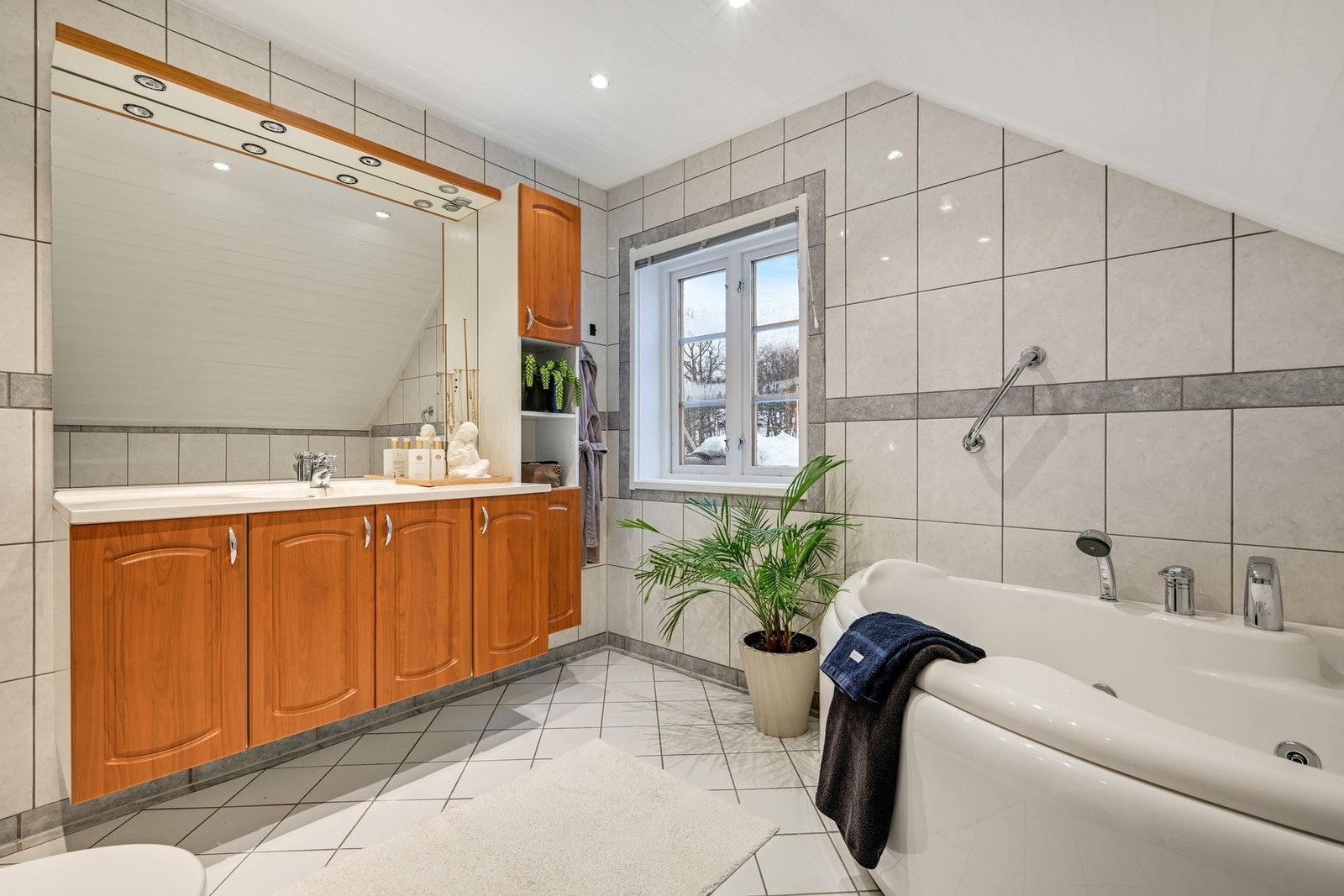 Et flislagt og romslig bad - godt med skapplass og både dusj og badekar Galleribilde