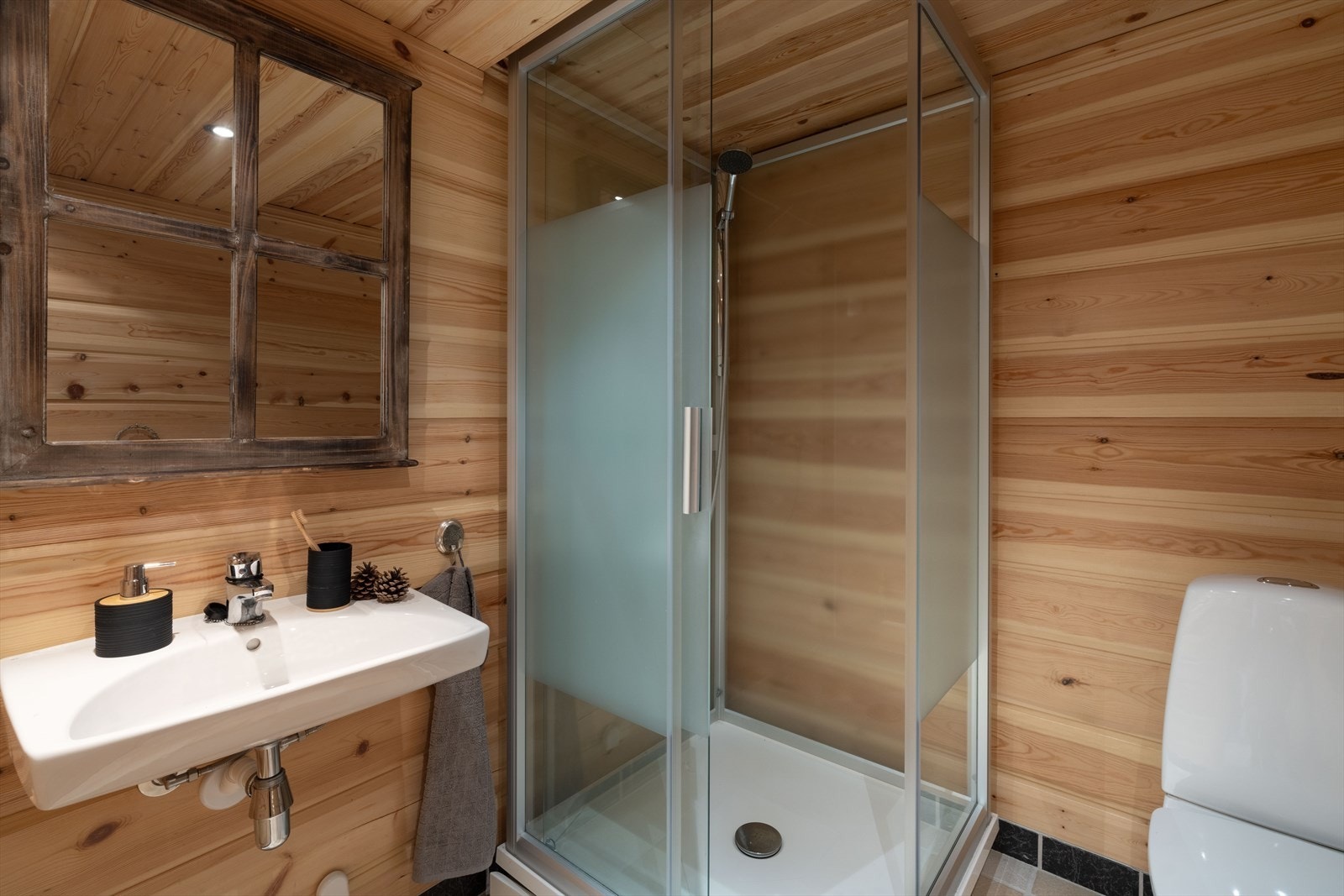 Bad innredet med dusjkabinett, vask og toalett. Galleribilde