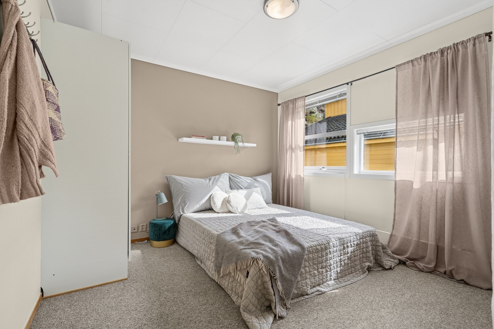 Hovedsoverommet har lunt teppe på gulv, skap og store vindusflater Galleribilde