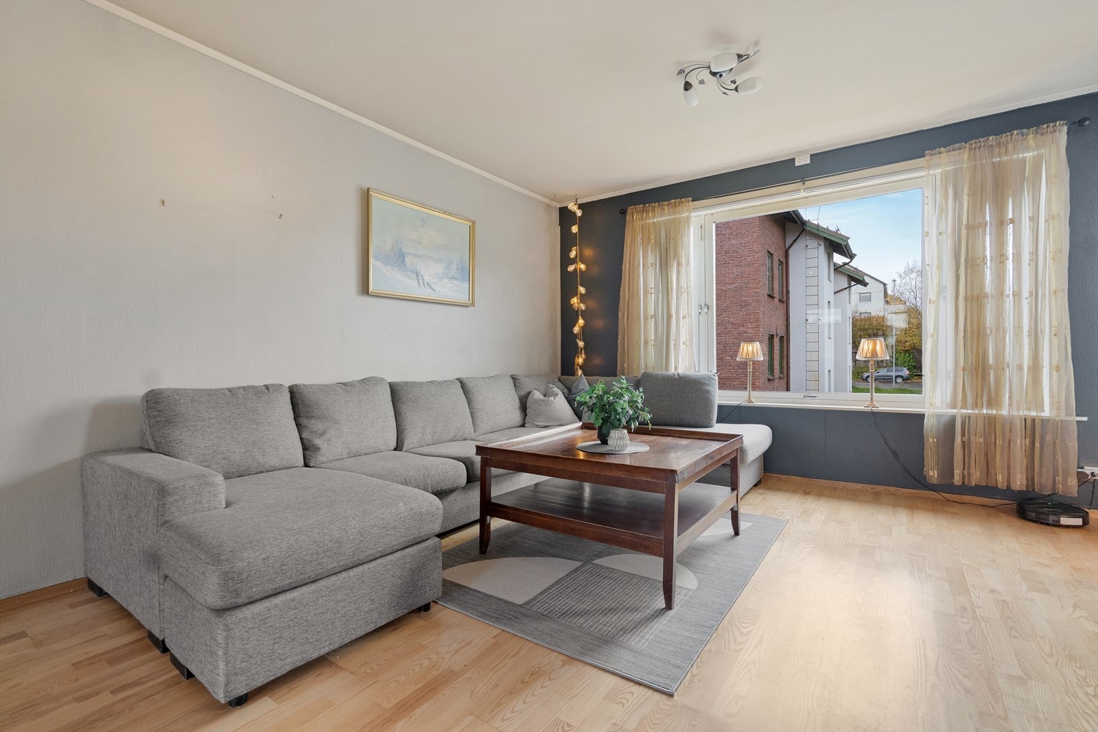 Hyggelig sofakrok med lysinnslipp fra vinduene - et perfekt samlingspunkt for familie og venner Galleribilde