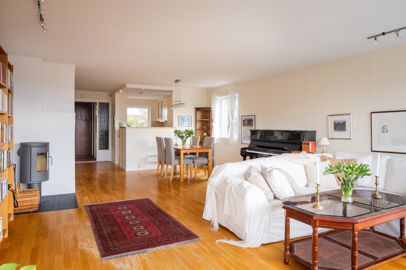 Lys og romslig stue med peis og generøst lysinnslipp fra tre himmelretninger Galleribilde