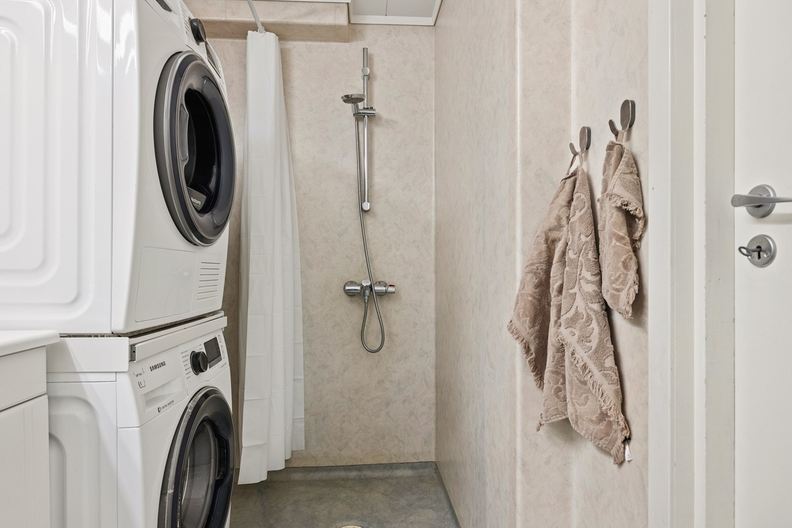 Badet er utstyrt med dusjhjørne, gulvstående toalett og opplegg for både vaskemaskin og tørketrommel. Galleribilde