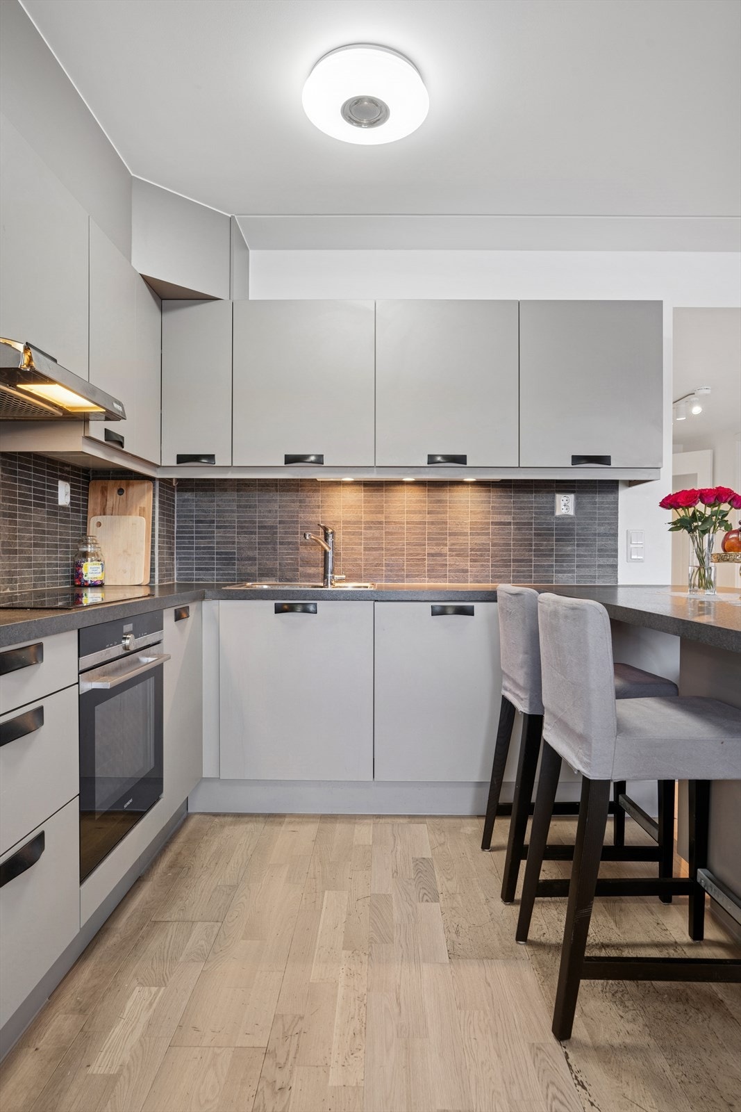 Innredningen består av under- og overskap med slette fronter, og benkeplaten er i laminat med nedfelt kum i rustfritt stål og ett- greps blandebatteri. Galleribilde