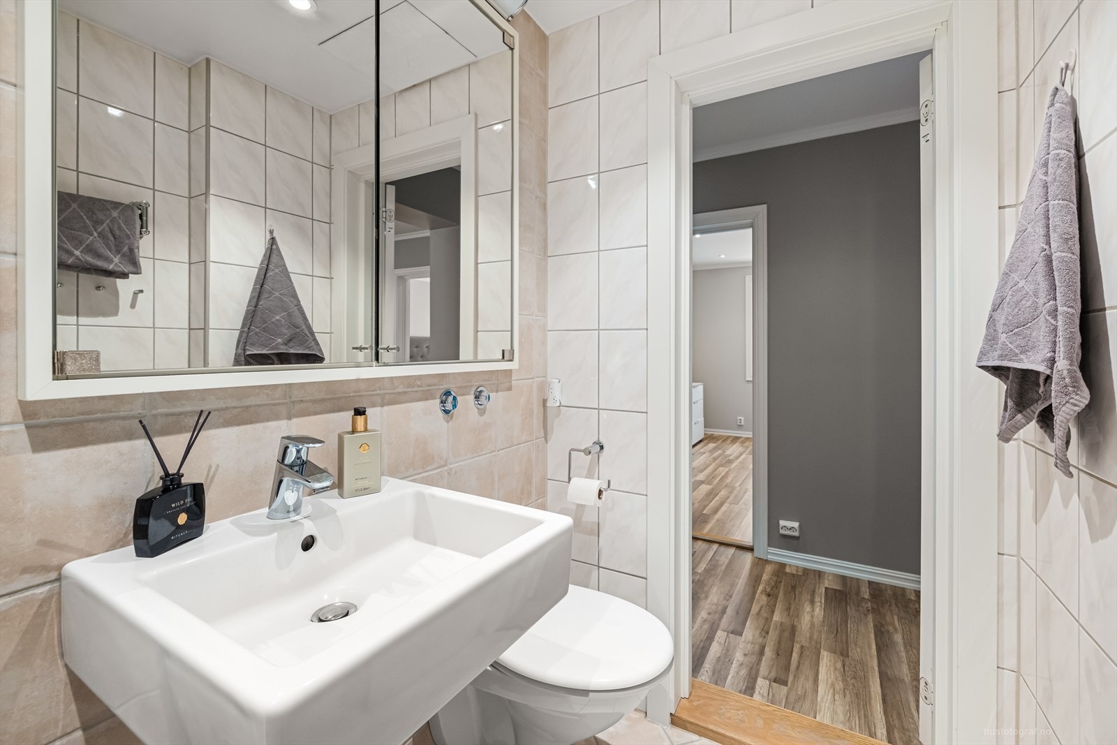 Badet har nedfelt servant, vegghengt toalett, speil skap til oppbevaring. Galleribilde