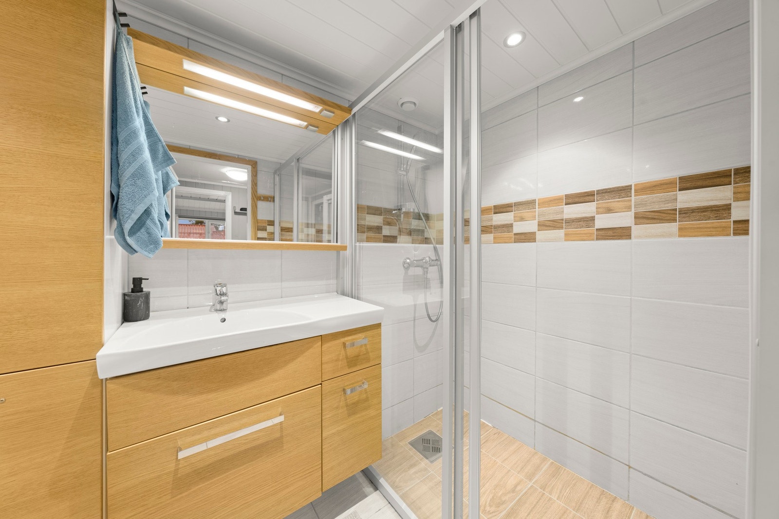 Veggene har fliser og taket har panel. Det er plastsluk i dusjen. Galleribilde