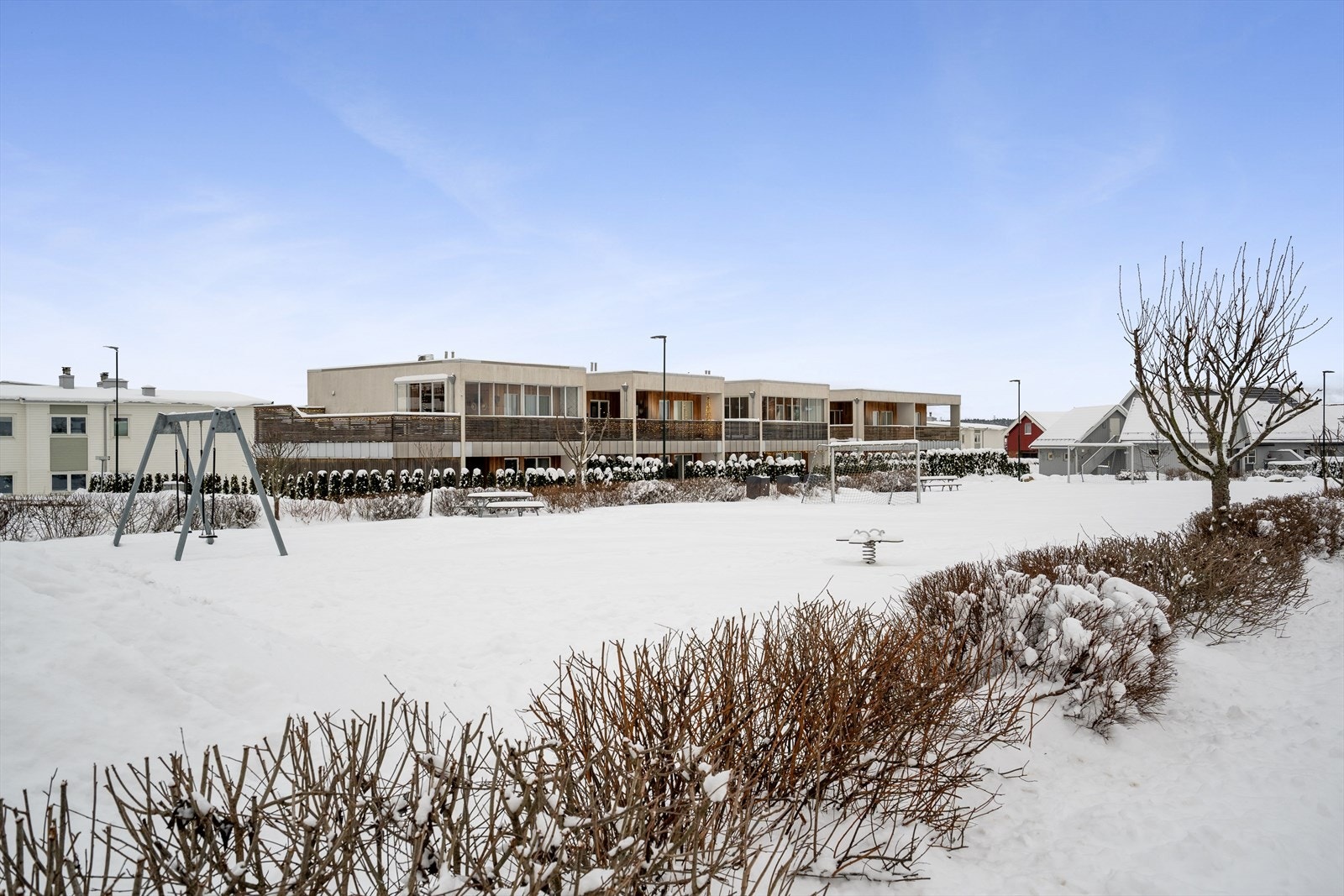 Et hyggelig tun utenfor eiendommen, med grøntområde, lekeplass og forballbane. Galleribilde