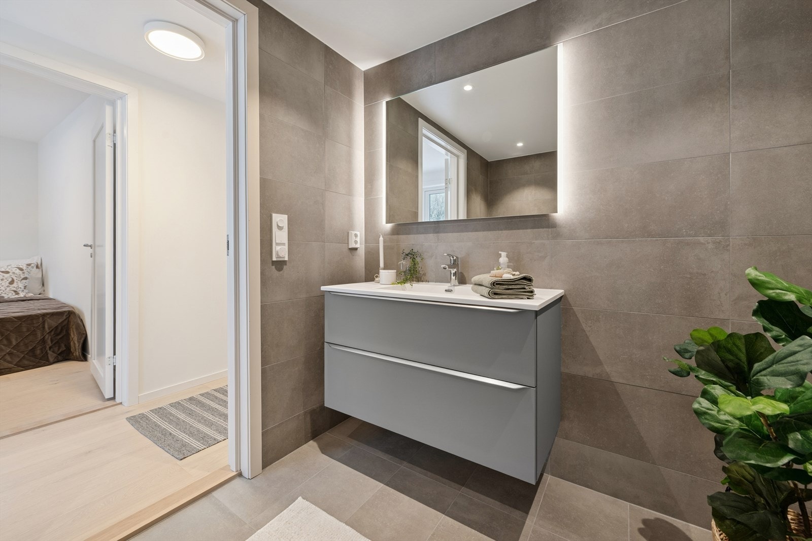 Flislagte vegger og gulv med varmekabler gir et moderne bad med komfort. Galleribilde