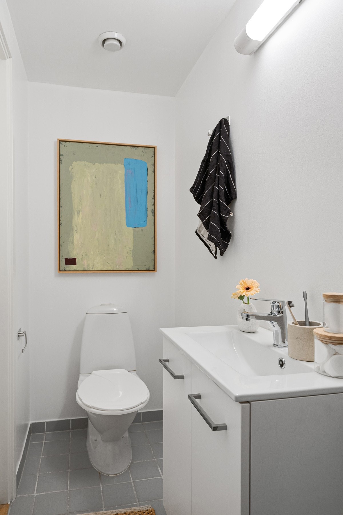 Badet inneholder servant med underskap, dusjhjørne og toalett. Galleribilde