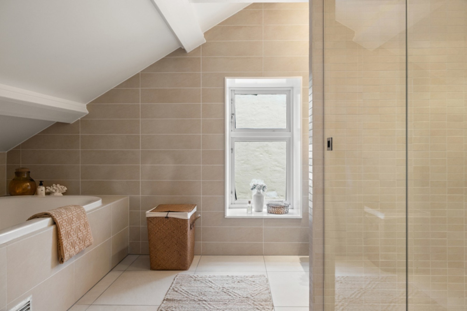 Flotte beige fliser på gulv og vegger, samt takbjelker i himling som øvrige deler i boligen Galleribilde