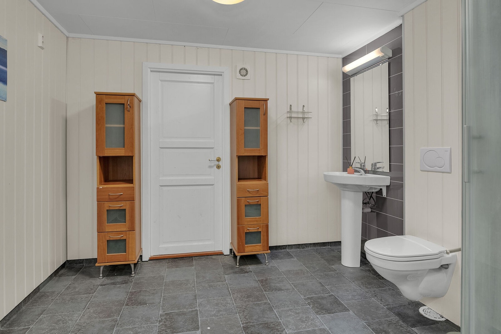 Badet fra 2012 er utført med gulvbelegg med elektriske varmekabler, våtromsplater og malte plater på veggene (ikke omsøkt). Galleribilde