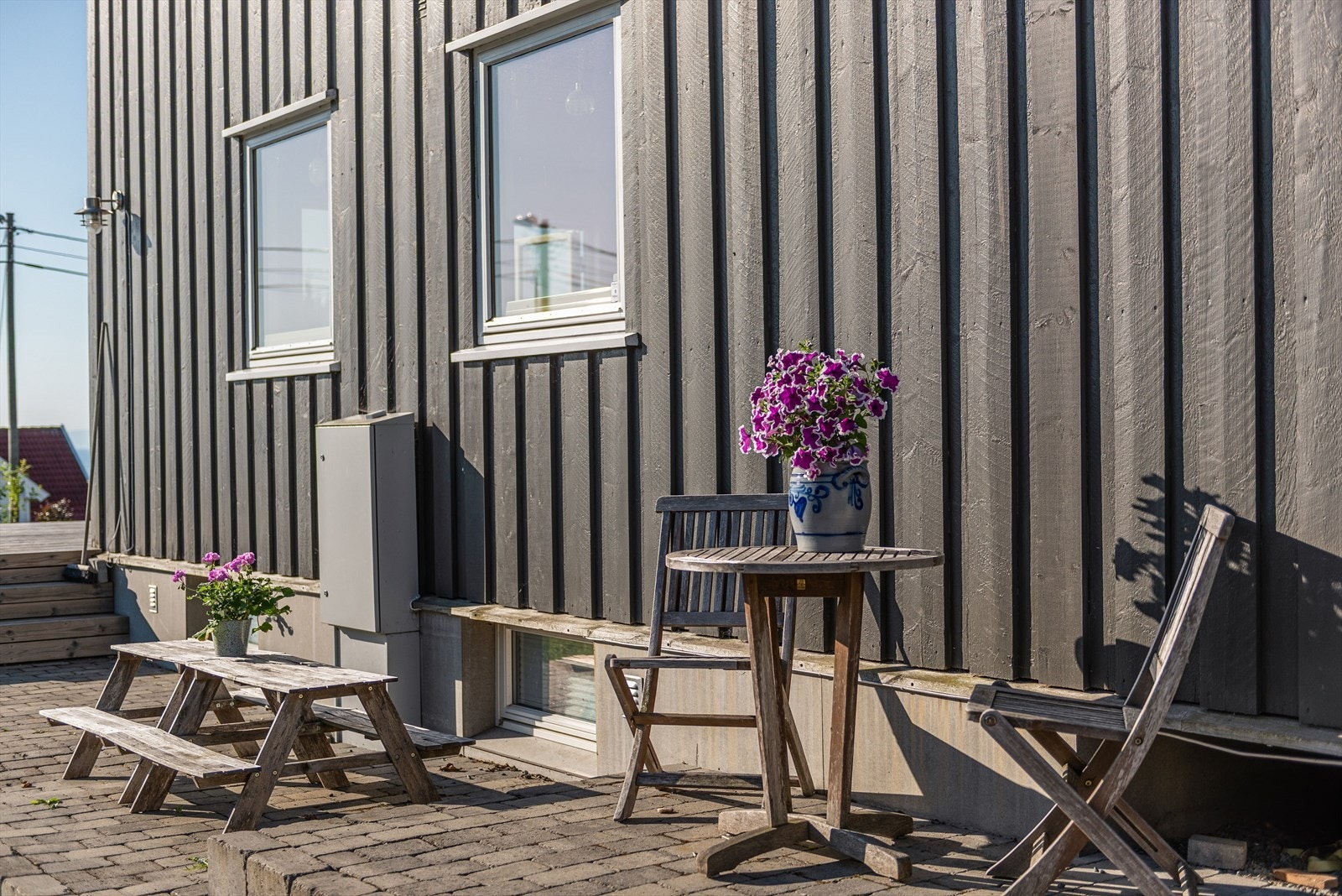 Detalj - Steinsatt uteplass langt husveggen. Galleribilde