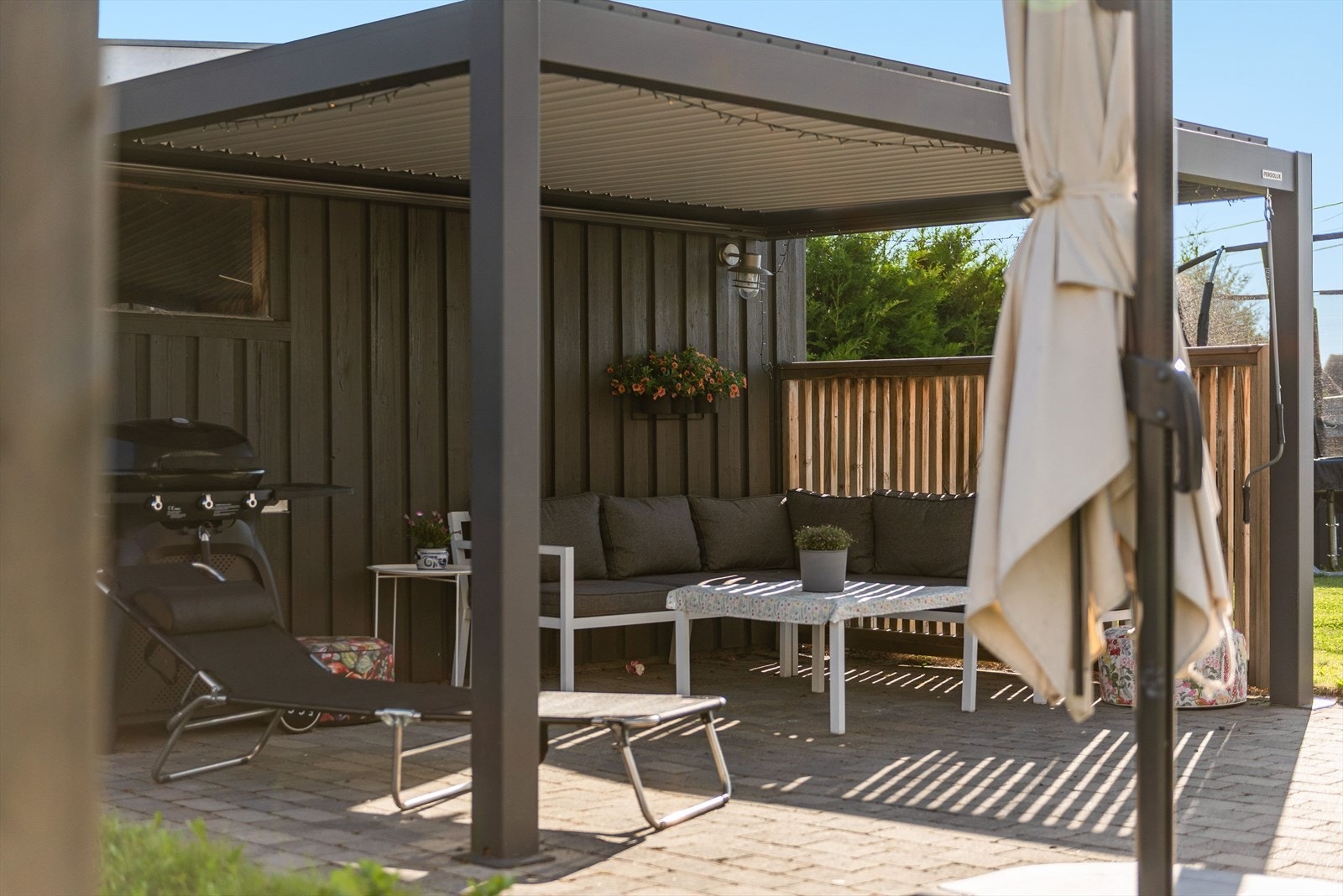 Boligen har en pent opparbeidet tomt med mange ulike soner - Her pergola ved inngangsparti. Galleribilde