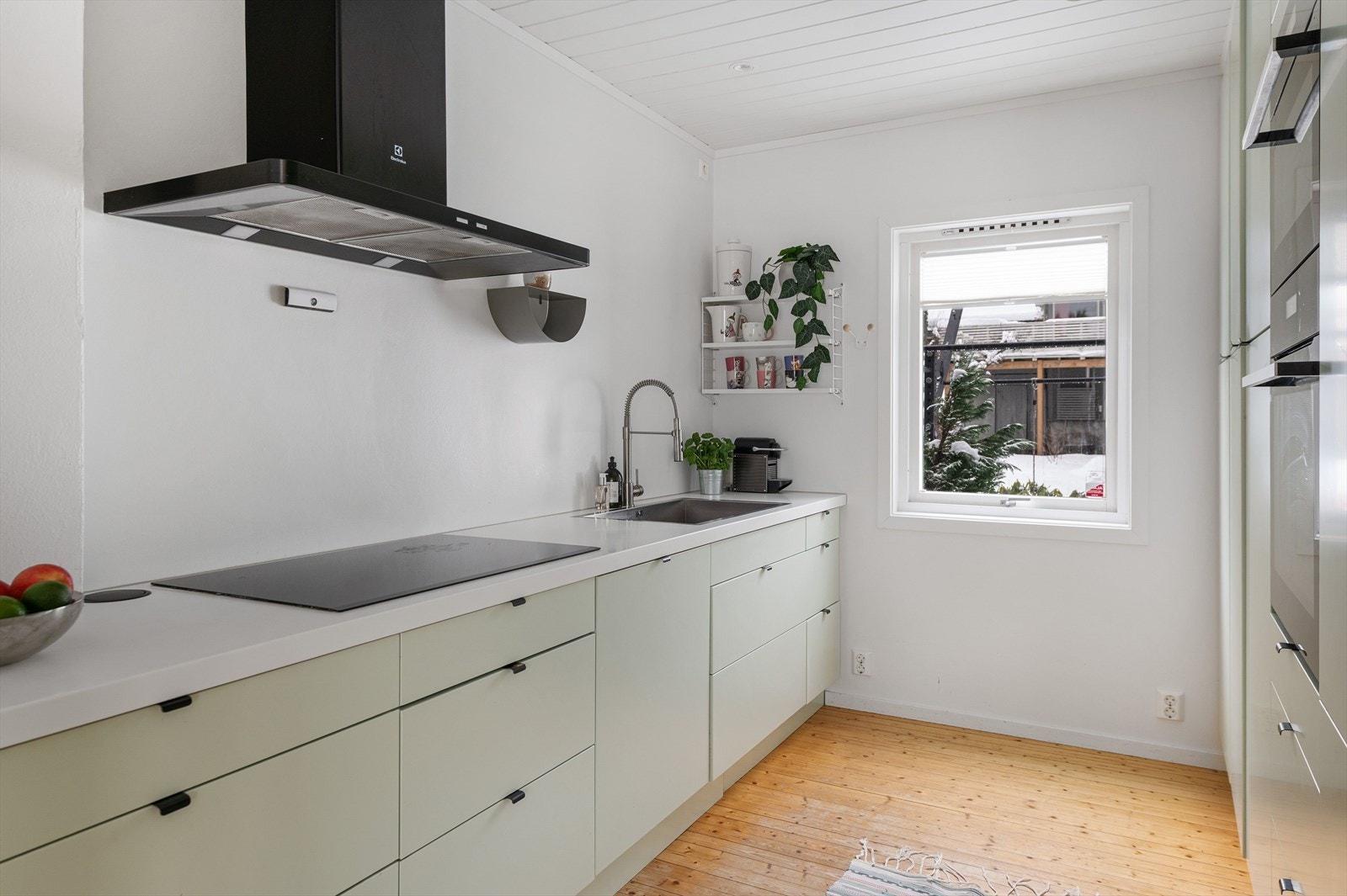 Stilrent og moderne kjøkken med glatte fronter, integrerte hvitevarer og benkeplate i laminat. Galleribilde