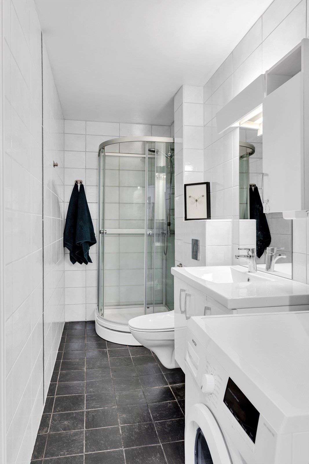 Baderomsinnredning med god oppbevaringsplass, samt opplegg for vaskemaskin. Galleribilde