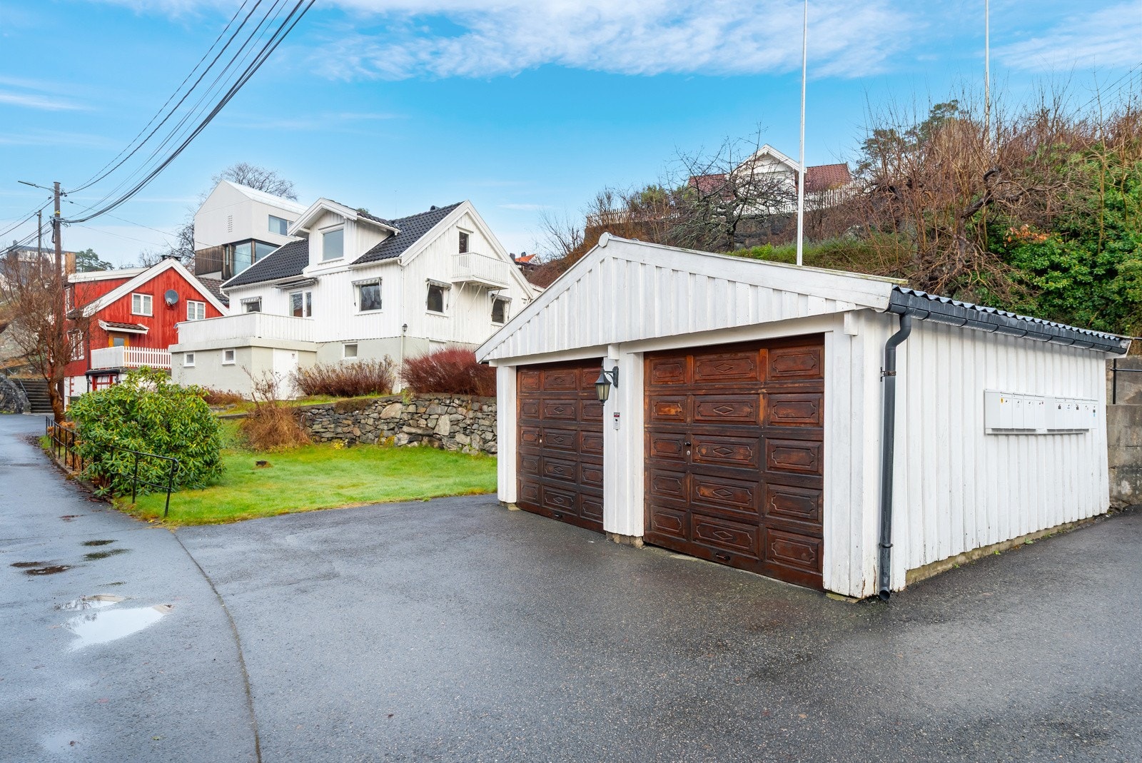 Garasjen er av ukjent byggeår og ligger på egen parsell som medfølger i salget. Det er plass til to biler i garasjen, og en biloppstilling fremfor hver port. Galleribilde