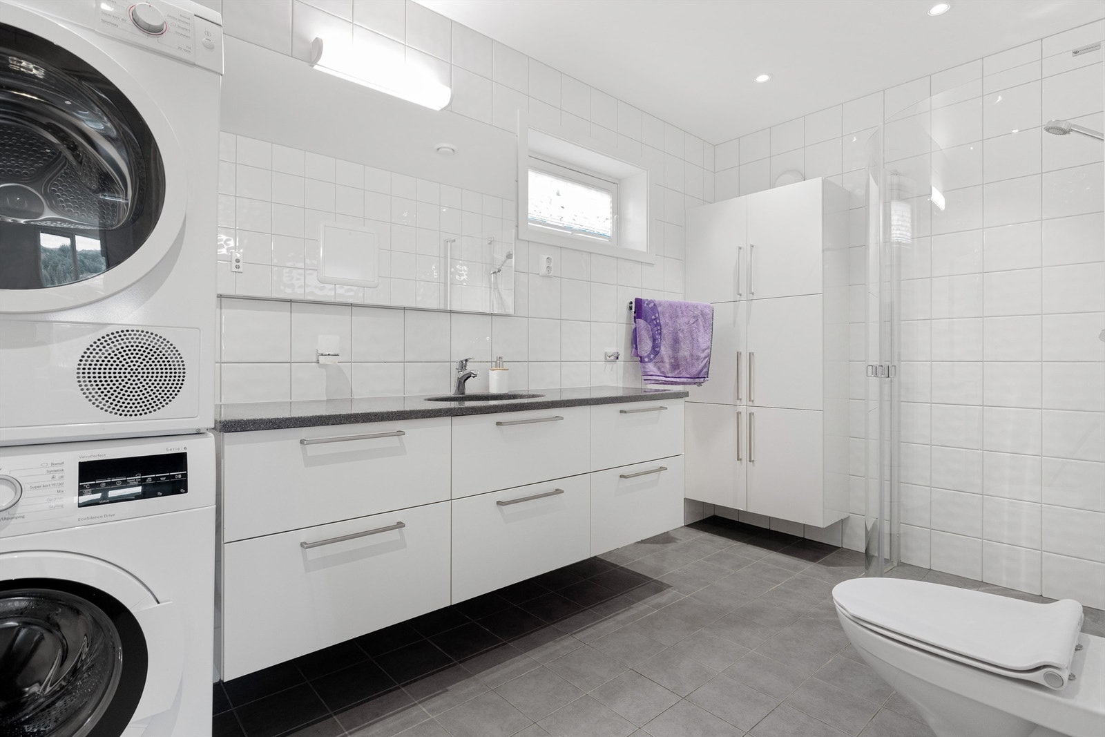 Stort flislagt bad på ca 6,5 kvm. med uttak for både vaskemaskin og tørketrommel. Galleribilde