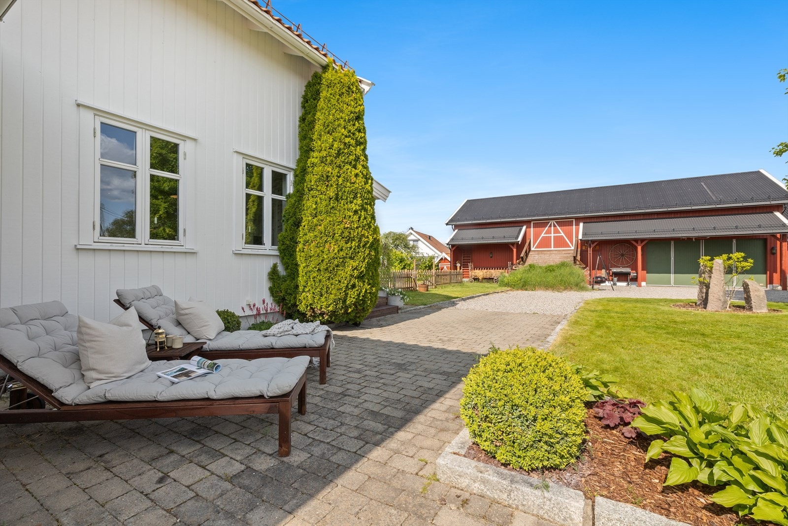 Den vakre hagen er omkranset av et elegant smijerns-gjerde, og midt i hagen står en stolt flaggstang. Galleribilde