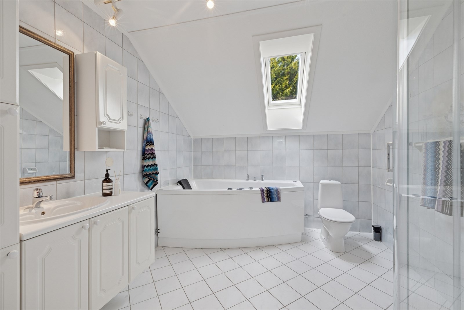 Hovedbadet i andre etasje er flislagt og romslig, med heldekkende servant, vegghengt speil, høyskap, toalett og dusjkabinett. Badet har varmekabler i gulvet og et flott frittstående massasjebadekar fra 2010. Galleribilde