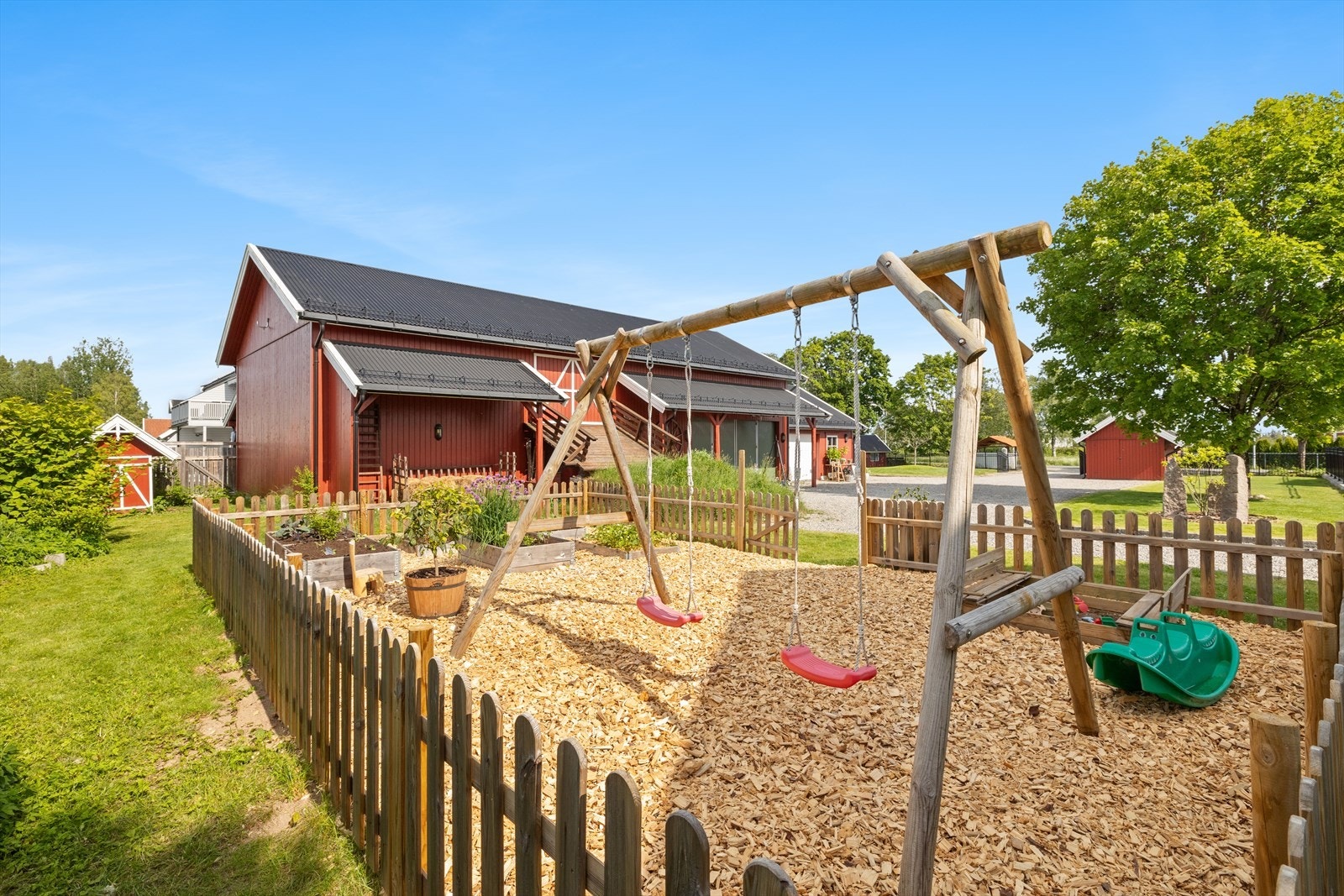 Det er anlagt en kombinert lekeplass og grønnsakshage, omkranset av et tregjerde. Galleribilde
